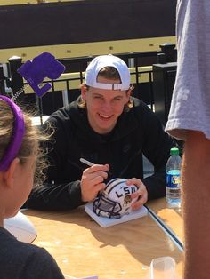 a man sitting at a table with a cake in front of him and two other people