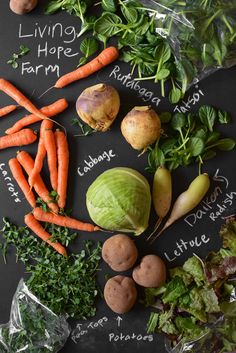 an assortment of vegetables laid out on a chalkboard