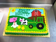 a birthday cake decorated with farm animals on a metal surface in front of a machine