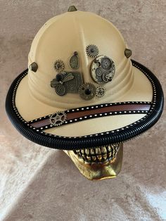 This hat is a costume-quality hat with fabric over something light (plastic? Foam?).    It has an elastic sweatband and ranges 55-58 cm.  It fits my oval 22 inch head fine.   Can be remade on request, though the fittings will vary with materials.   The hat is embellished with a variety of metal gears, studs, etc., with corrugated piping around the edge. More hats available at tricornes.shop without added ETSY fees. Adjustable Steampunk Masks And Prosthetics For Costumes, Steampunk Adjustable Masks And Prosthetics For Festivals, Adjustable Steampunk Masks And Prosthetics For Festival, Adjustable Hats For Halloween Themed Events, Adjustable High Crown Top Hat For Themed Events, Themed Adjustable Costume Hats For Cosplay, Adjustable Costume Hats For Themed Events, Adjustable Cap For Costume, Adjustable Costume Cap