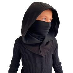 a young child wearing a black hood and sweater with the hood pulled over it's face