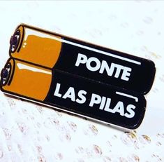 two black and yellow pins with the words ponte las pilas on them