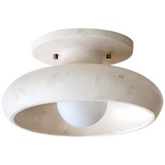 a white light that is on top of a ceiling fixture in the shape of an object