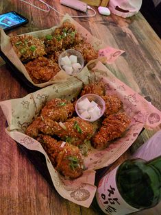 two baskets filled with food sitting on top of a wooden table next to a bottle of wine