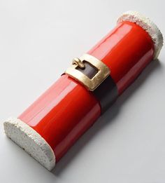 a piece of red and white paper with a gold buckle on it's end