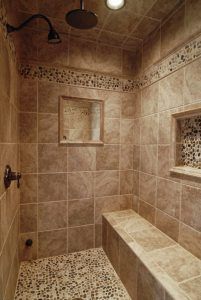 a walk in shower sitting next to a window and tiled walls with decorative tiling