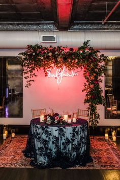 the reception table is set up with candles, flowers and greenery for an intimate dinner