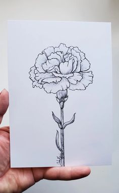 a hand holding a card with a drawing of a flower