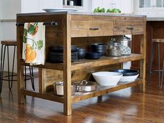 a kitchen island made out of wood with bowls and pans on the bottom shelf