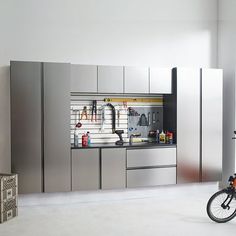 a bike parked next to a kitchen with stainless steel cabinets