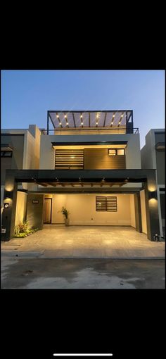 an image of a house that is lit up in the evening with lights on it