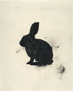 a black and white photo of a rabbit sitting on the ground with dirt all over it