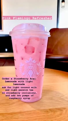 a pink drink sitting on top of a wooden table