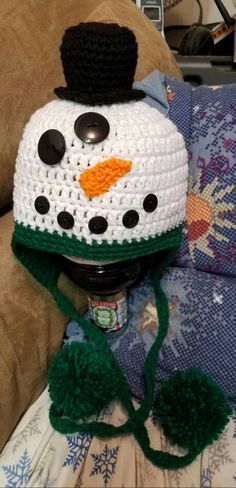 a crocheted snowman hat sitting on top of a couch