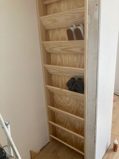 a wooden shelf with shoes on it in a room