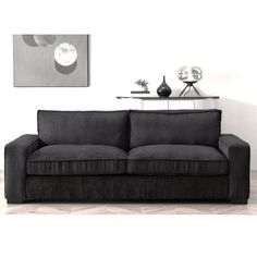 a black couch sitting in front of a white wall