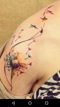 a woman's stomach with a dandelion tattoo on her belly and side