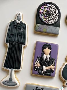 decorated cookies with pictures of women in black and white outfits on top of a table