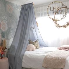 a bed with a canopy over it in a room filled with furniture and flowers on the wall