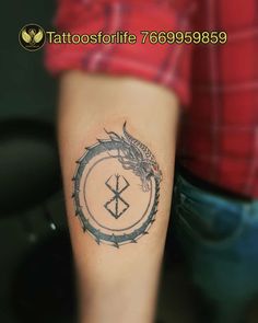 a person with a tattoo on their arm and a dragon in the middle of it