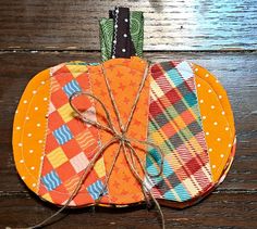 an orange patchwork pumpkin sitting on top of a wooden table