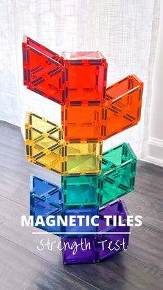 a stack of colorful plastic blocks sitting on top of a wooden floor