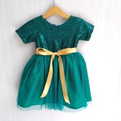 Emerald green sequin flower girl dress with matching dark green tulle skirt. The back is closing with invisible zipper and gold satin ribbon with tie at the backHave a hunter green, emerald green or forest green wedding theme? Then this is a perfect dress for your cute little flower girl. The tutu dress can also be a Birthday Dress, Christmas dress or to attend semi formal to formal occasionIff you want to have a different color for the tutu skirt or ribbon just leave me a note at the 'message t Emerald Green Flower Girl Dress, Green Flower Girl Dress, Green Tulle Skirt, Green Flower Girl Dresses, Forest Green Wedding, Sequin Flower Girl Dress, Girls Navy Dress, Girl Green Dress, Green Sequin Dress