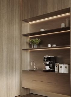 a coffee maker is sitting on the counter next to some shelves with cups and mugs