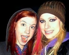 two young women are posing for a photo together, one with red hair and the other with blue eyes