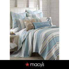 a bed covered in blue and white striped comforter with starfish on the pillow