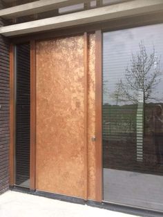 the front door to an apartment building with glass and wood panels on it's sides