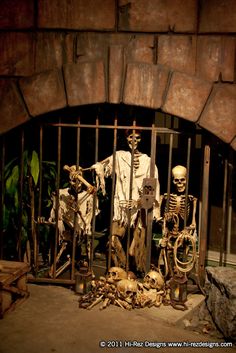 skeleton statues in front of an iron gate