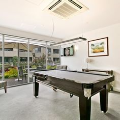 a pool table in a room with sliding glass doors