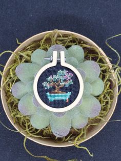 a small potted plant in a basket with some thread