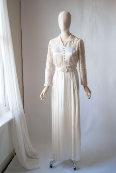 "Era: 1940 Details: Elegant 1940's lace and satin bridal dress with decorative cover buttons and gathered waistline design. Matching belt with pearlised celluloid belt buckle, this dress is worn over the head.  Measurements:  Best Fits Size M-L/ UK 10- 12  Shoulders: 14\" Sleeves: 22\"  Bust: 36\" Waist: 33\"  Belt: up to 30\" (could be taken in to reduce waist size if desired) Hips: 42\"  Length: 58\" Fabric: Rayon satin and lace Condition: Good Vintage Condition, weakening to the lace at underarms and shoulders, a couple of light marks to the skirt, has been dry cleaned. If appropriate for the garment, I always wash or dry clean Dressed in History vintage items before offering them for sale and they will arrive with you in clean condition. Vintage items have lived a life prior to reachin Vintage Satin Dress For Wedding Night, Vintage Cream Satin Dress, Reduce Waist Size, Satin Bridal Dress, 40s Outfits, Chiffon Mini Dress, Beaded Chiffon, Gowns For Girls, Photo Journal