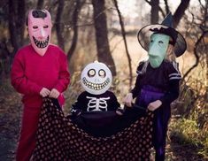 three children in halloween costumes standing next to each other