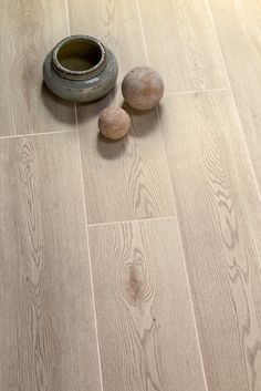 three rocks sitting on the floor next to a vase