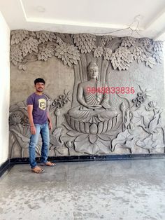 a man standing in front of a wall with an image of buddhas on it