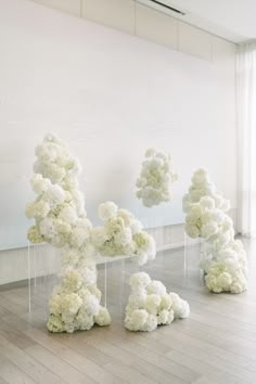 four clear acrylic sculptures with white flowers on them