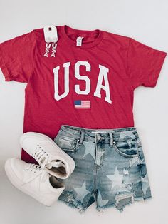 Celebrate your love for the USA with our USA Flag Graphic Tee! Made of super soft material, this unisex tee features a bold USA screen print. Show off your patriotic pride in style and comfort. Available in sizes S-2XL. Graphic Tee Dress, Swim Shop, Top Graphic Tees, Glitz And Glam, Tee Dress, Red And Grey, Gift Accessories, Usa Flag, Dress Romper