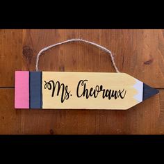 a wooden sign that says mr and mrs choraux hanging from a string on a wood floor