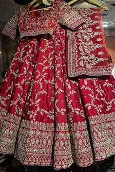 Red attached cancan flared lehenga with embroidery using mix material of dabka dori, sitara sequins, zari, beads and pearls in floral jaal motifs. Paired with a padded blouse with embroidery using similar work and a belt with coordinating mobile packet. Comes along with a veil dupatta with embroidered and kiran lace border and a second dupatta with dabka, sitara embroidery. - Aza Fashions Red Gown With Dori Work For Navratri, Traditional Red Raw Silk Set, Red Floor-length Raw Silk Sharara, Red Floor-length Lehenga With Dori Work, Red Raw Silk Lehenga With Pallu, Red Raw Silk Gown For Navratri, Red Floor-length Lehenga For Traditional Ceremonies, Red Raw Silk Choli For Wedding, Red Raw Silk Choli For Traditional Ceremonies