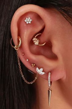 a woman wearing three different ear piercings and one with a flower on the side