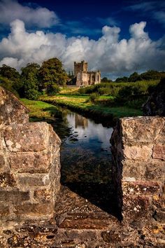 an old castle sits on the edge of a river