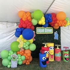 the balloon arch is decorated with colorful balloons and sesame street characters on it's sides