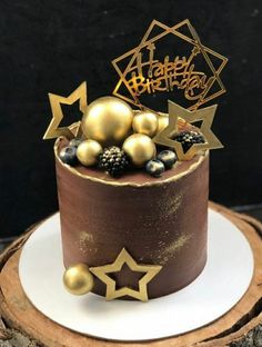 a chocolate cake with gold decorations and stars on top