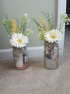 two mason jars with flowers in them on the floor