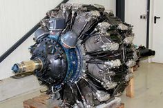 an airplane engine sitting on top of a wooden pallet in a building with white walls