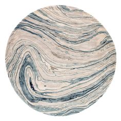 a round rug with blue and white swirls on the top, in front of a white background