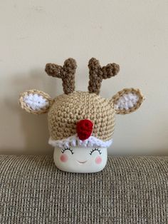 a crocheted reindeer hat with a red nose and antlers on it's head